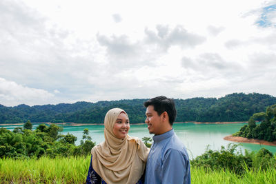 Friends enjoying in lake against sky