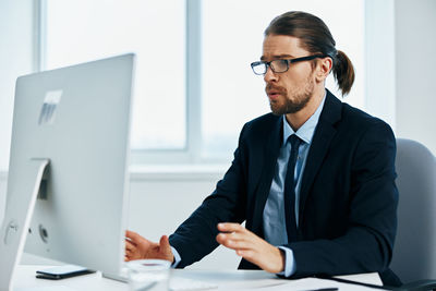 Young man using mobile phone while sitting on table