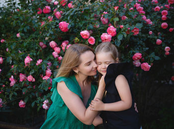 Happy woman with pink flowers against plants