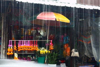 Multi colored flags hanging on glass window