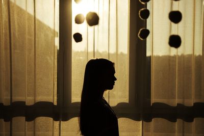 Silhouette of person by window