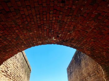 Low angle view of brick wall against sky
