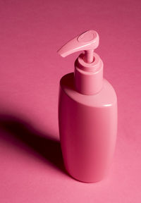 Close-up of bottle against pink background