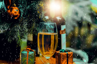 Close-up of wine glass on illuminated christmas tree