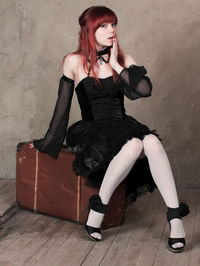 Full length of young woman sitting outdoors