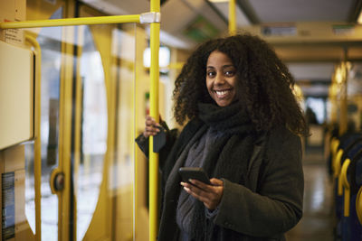 Woman in bus holding cell phone