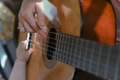 Midsection of man playing guitar