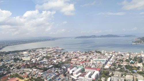 High angle view of townscape by sea against sky