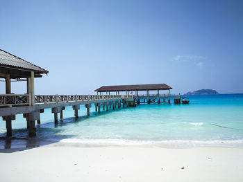 Built structure on beach against clear blue sky