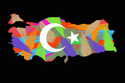 Close-up of multi colored umbrellas on paper against black background