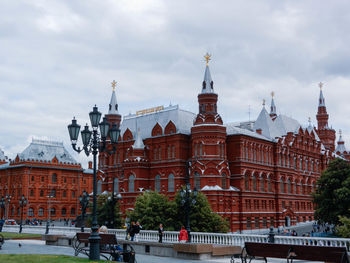 Buildings in city against cloudy sky