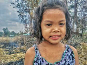 Close-up portrait of cute girl standing against trees