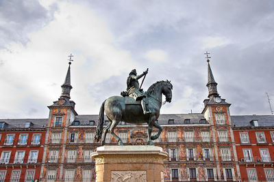 Statue of historic building against cloudy sky