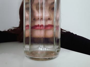 Close-up portrait of woman in glass