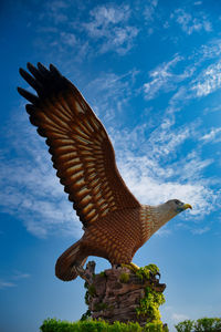 Low angle view of bird sculpture against blue sky