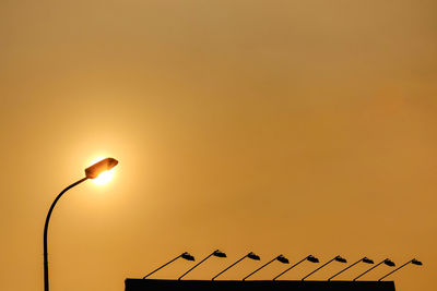 Low angle view of birds perching on street light