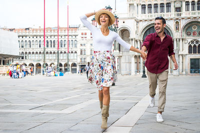 Smiling couple embracing against historic building