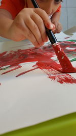 Close-up of boy painting on paper