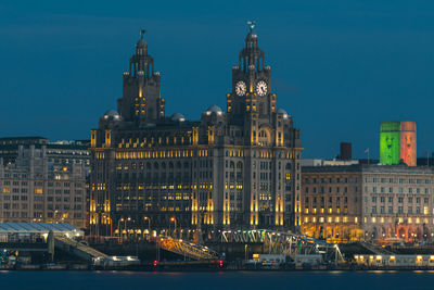 Illuminated buildings against sky at night