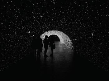 People walking on footpath at night