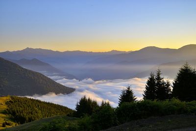 Scenic view of cloudscape amidst mountains during sunset