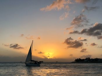 Sailboat sailing on sea against sky during sunset