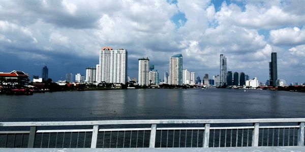 River by city buildings against sky