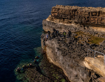 High angle view of people on rock by sea