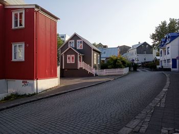 Street by buildings against sky in city