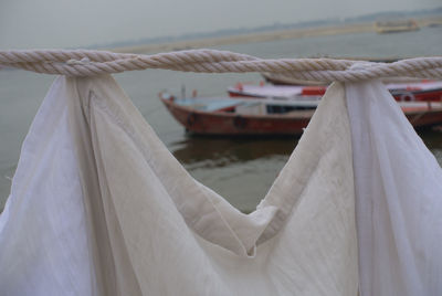 Close-up of rope tied to boat moored in sea
