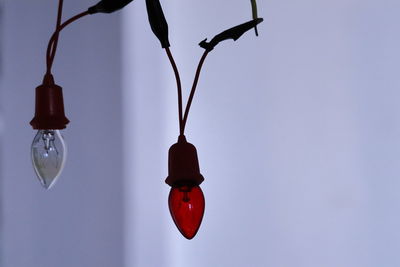 Low angle view of electric lamp hanging against sky