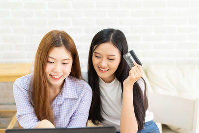 Smiling young woman using smart phone