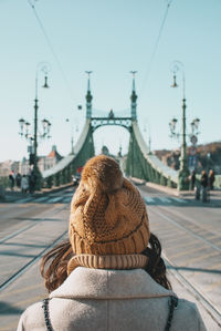 Rear view of woman standing on street in city