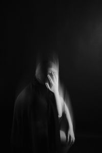 Full length portrait of man against black background