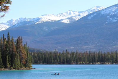 Scenic view of lake by snowcapped mountains against sky