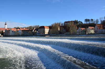 Houses against clear blue sky during winter