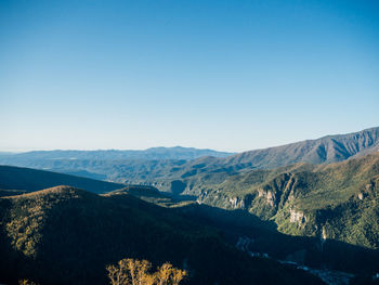 Panoramic view of landscape and mountains against clear blue sky