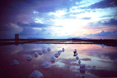 Scenic view of sea against cloudy sky at sunset