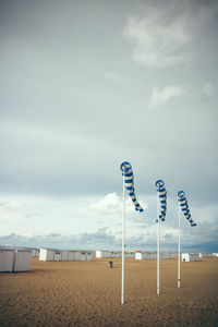 Sign board on beach against sky