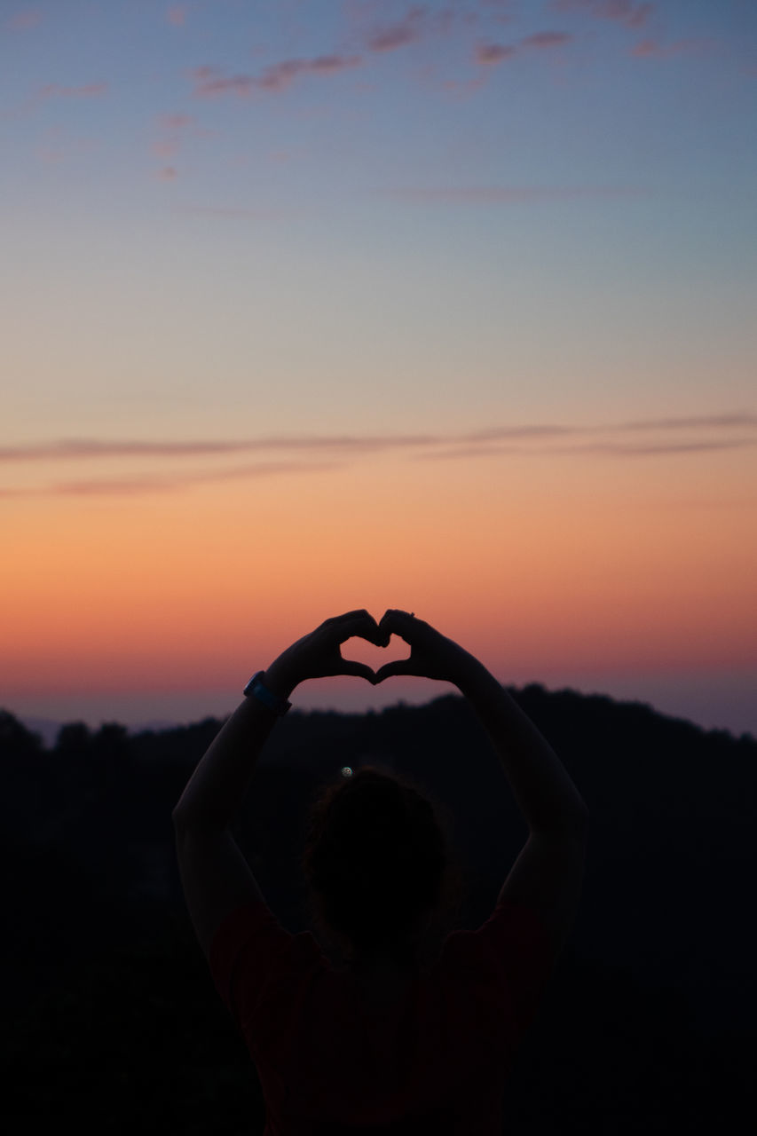 SILHOUETTE WOMAN WITH HEART SHAPE AGAINST ORANGE SKY