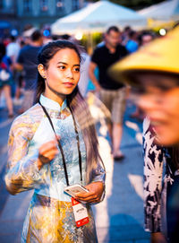 Young woman using phone while standing on street