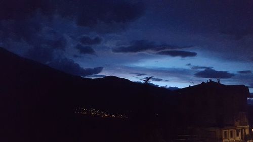 Scenic view of landscape against cloudy sky at dusk