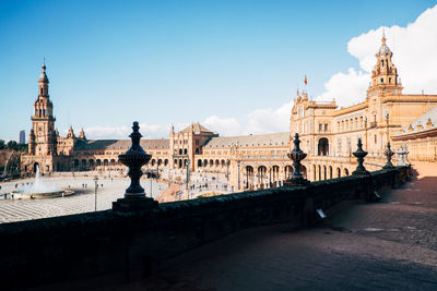 Historic buildings at plaza de espana against blue sky