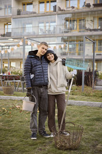 Young people holding garden tools