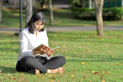 Full length of woman sitting on field