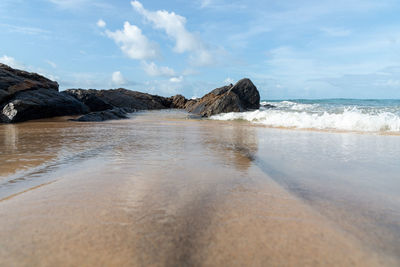 A wave breaks about a rock during a curtain on the sea. farol da barra beach, salvador, brazil.