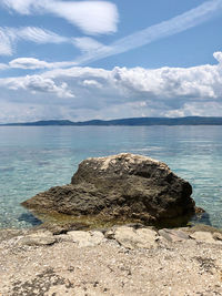 Rock formation on sea shore against sky