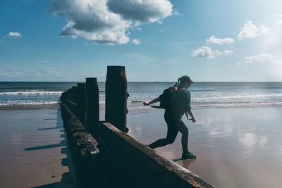 Full length of man standing on beach against sky