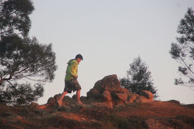 Full length of man standing on rock against sky