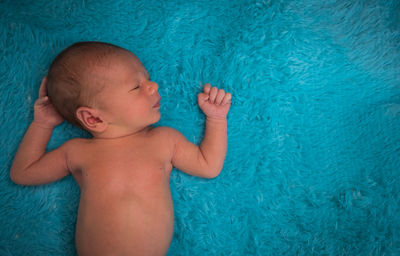 Directly above shot of cute newborn sleeping on bed at home